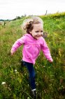Smiling girl running through a meadow, Poland — Stock Photo