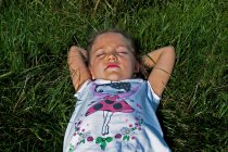 Visão aérea de uma menina deitada em um prado no sol de verão, Polônia — Fotografia de Stock