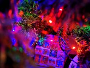 Primer plano de luces de hadas multicolores y regalos bajo un árbol de Navidad - foto de stock