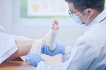 Medico che analizza la degenerazione dell'osso della caviglia nel suo ufficio in ospedale — Foto stock