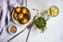 Delicious new potatoes in a bowl sprinkled with chopped thyme herb served on a concrete table — Foto stock