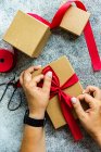 Ansicht einer Frau, die ein Weihnachtsgeschenk verpackt — Stockfoto