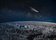 Comet passing over desert badlands, California, USA — Stock Photo