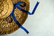 Overhead view of a Summer straw hat with a blue ribbon on a table — Stock Photo