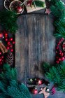 Рождественские безделушки, украшения и елки рядом с деревянной доской — стоковое фото