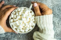 Vista aerea di una donna che tiene una tazza piena di mini marshmallow — Foto stock