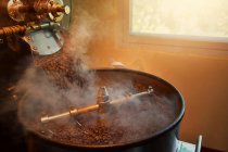 Крупным планом обжаривания кофейных зерен в кофейной жаровне — стоковое фото