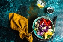 Gesundes Abendessen mit Bio-Gemüseschale auf einem Tisch mit Sesam und einem Glas Zitronenwasser — Stockfoto