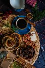 Café épicé de Noël dans une tasse en céramique bleue parmi les épices et les baies sur fond sombre et humide — Photo de stock