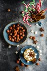 Becher voller Mini-Marshmallows mit Gewürzen auf dunklem Hintergrund als weihnachtliches Essenskonzept — Stockfoto