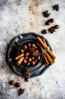 Концепція різдвяної їжі з старовинною чашкою з горіхами, паличками кориці та зіркою анісу на бетонному фоні — стокове фото
