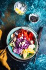 Cena saludable con verdura orgánica servida sobre una mesa con semillas de sésamo y un vaso de agua de limón - foto de stock