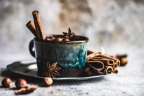 Weihnachtliches Essenskonzept mit Vintage-Becher voller Nüsse, Zimtstangen und Anis-Stern auf Betongrund — Stockfoto