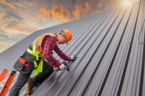 Roofer Trabalhador da construção instalar telhado novo. Ferramentas de cobertura. Furadeira elétrica usada em novos telhados com chapa metálica. — Fotografia de Stock