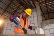 Muratore muratore posa di mattoni e barbecue edificio nel sito industriale — Foto stock