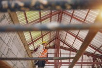 Roofer Trabajador de construcción instalar nuevo techo. Herramientas para techos. Taladro eléctrico utilizado en techos nuevos con chapa metálica. - foto de stock
