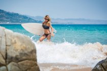 Молодая серфингистка на солнечном пляже — стоковое фото