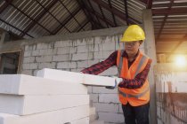 Рабочий-каменщик кладет кирпич и строит барбекю на промышленной площадке — стоковое фото