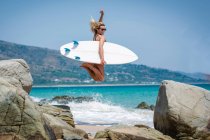 Jovem surfista mulher na praia ensolarada — Fotografia de Stock