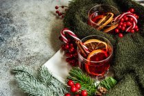 Concepto de bebida navideña con copa de vino caliente con especias alrededor - foto de stock