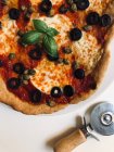 Vista superior de la pizza con aceitunas, alcaparras, mozzarella, tomate y albahaca - foto de stock