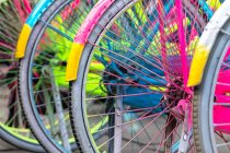 Rodas de bicicleta multicoloridas em um suporte de bicicleta — Fotografia de Stock