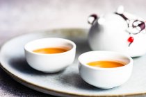 Duas xícaras de chá e bule no prato — Fotografia de Stock