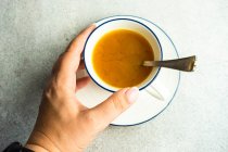 Top view of woman holding cup of turmeric tea — Stock Photo
