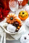 Otoño lugar de Acción de Gracias puesta en una mesa con adornos de calabaza y decoraciones de hojas - foto de stock