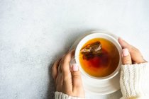 Top cropped view of a woman holding a cup of tea — Stock Photo
