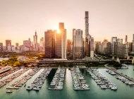 Vista aérea del horizonte de la ciudad y barcos en marina al atardecer, Chicago, Illinois, EE.UU. - foto de stock