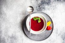 Beetroot cream soup with herbs in bowl with spoon — Stock Photo