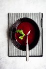 Rote-Bete-Sahne-Suppe mit Kräutern in Schüssel mit Löffel — Stockfoto