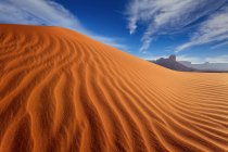 Вид рябь песчаной дюны с видом на далекие скалы — стоковое фото