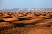 Schöne Aussicht auf Sanddünen und weit entfernte Felsen in der Wüste — Stockfoto