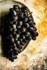 Cacho de uvas pretas no final da superfície rústica — Fotografia de Stock