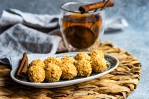 Healthy homemade candy balls coated in chopped nuts with cup of tea — Stock Photo
