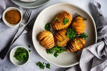 Tasty hasselback potatoes with fresh herbs — Stock Photo
