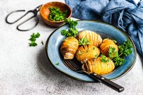 Schüssel Hasselback-Kartoffeln mit frischer Petersilie und Gabel — Stockfoto