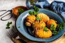 Bol de pommes de terre hasselback au persil frais servi sur la table — Photo de stock