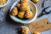 Healthy homemade candy balls coated in chopped nuts next to a good morning tag — Stock Photo