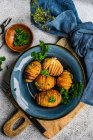 Schüssel Hasselback-Kartoffeln mit frischer Petersilie, Draufsicht — Stockfoto