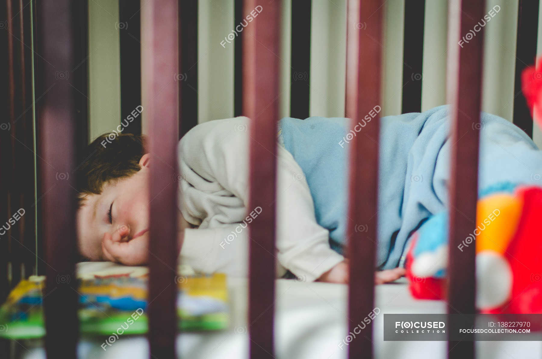 Boy sleeping in crib — lifestyle, wooden Stock Photo 138227970