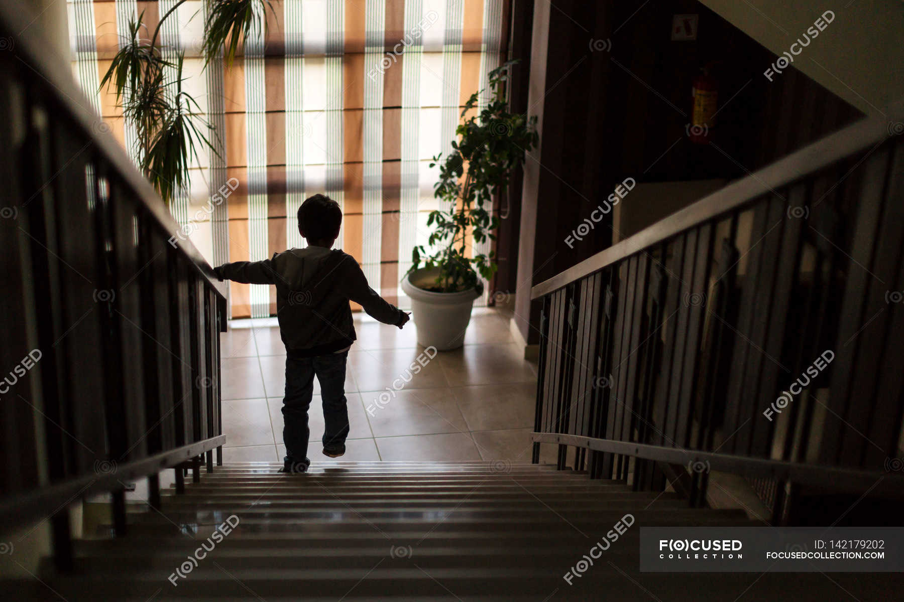 Я закрываю дверь и спускаюсь вниз. Мальчик бежит по лестнице. Мальчик спускается по лестнице. Лестница для детей. Дети бегают по лестнице.