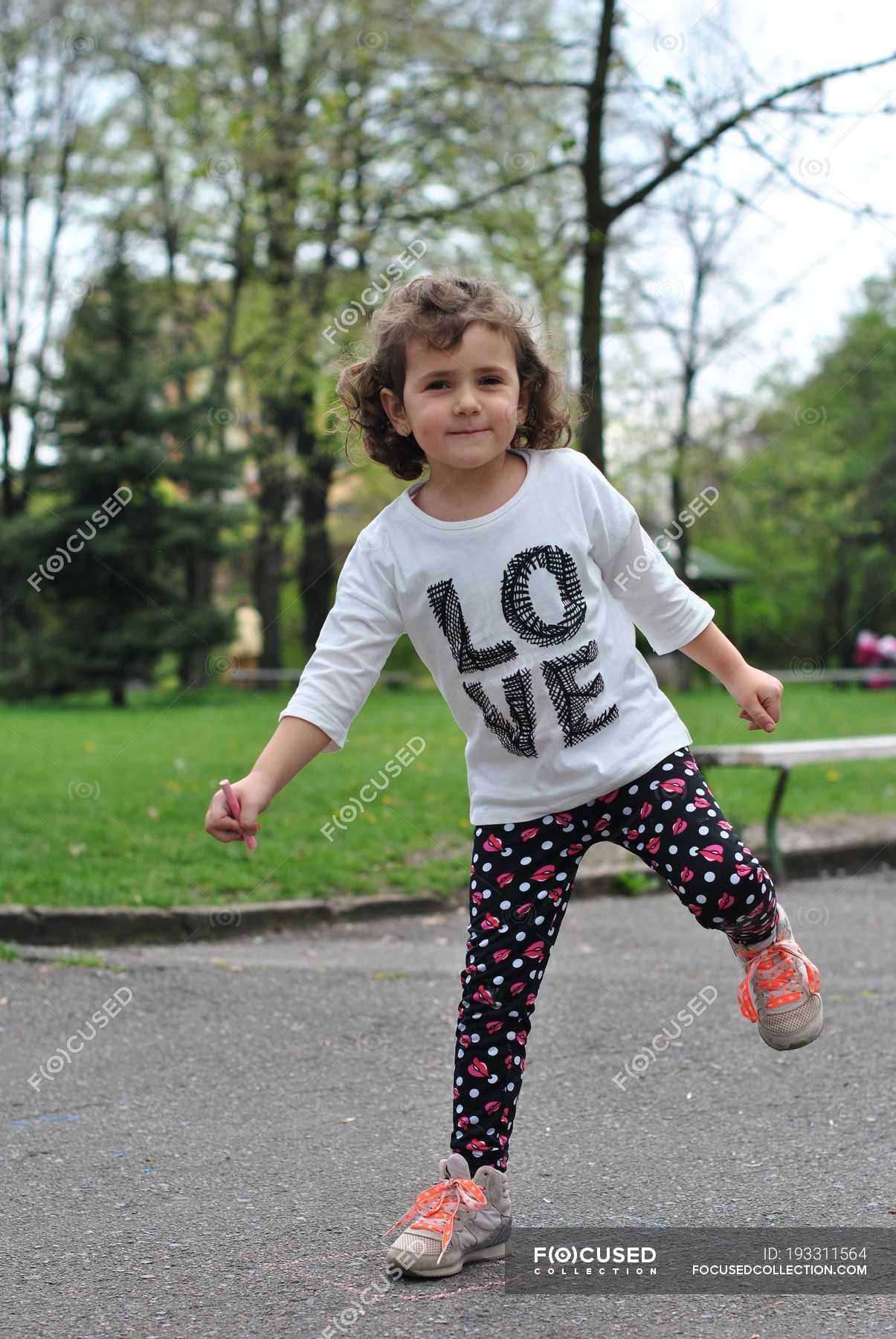 Girl Playing Hopscotch On Street And Looking At Camera — Carefree, Fun 