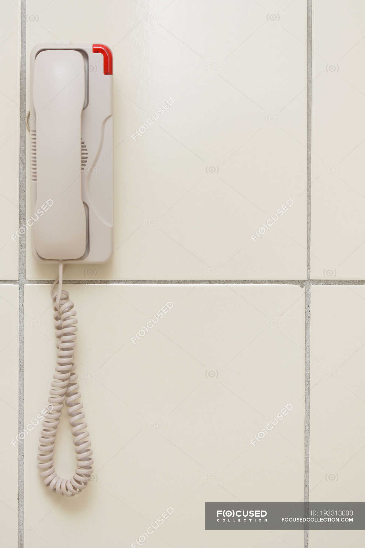 Closeup view of white phone hanging on wall — landline phone, call