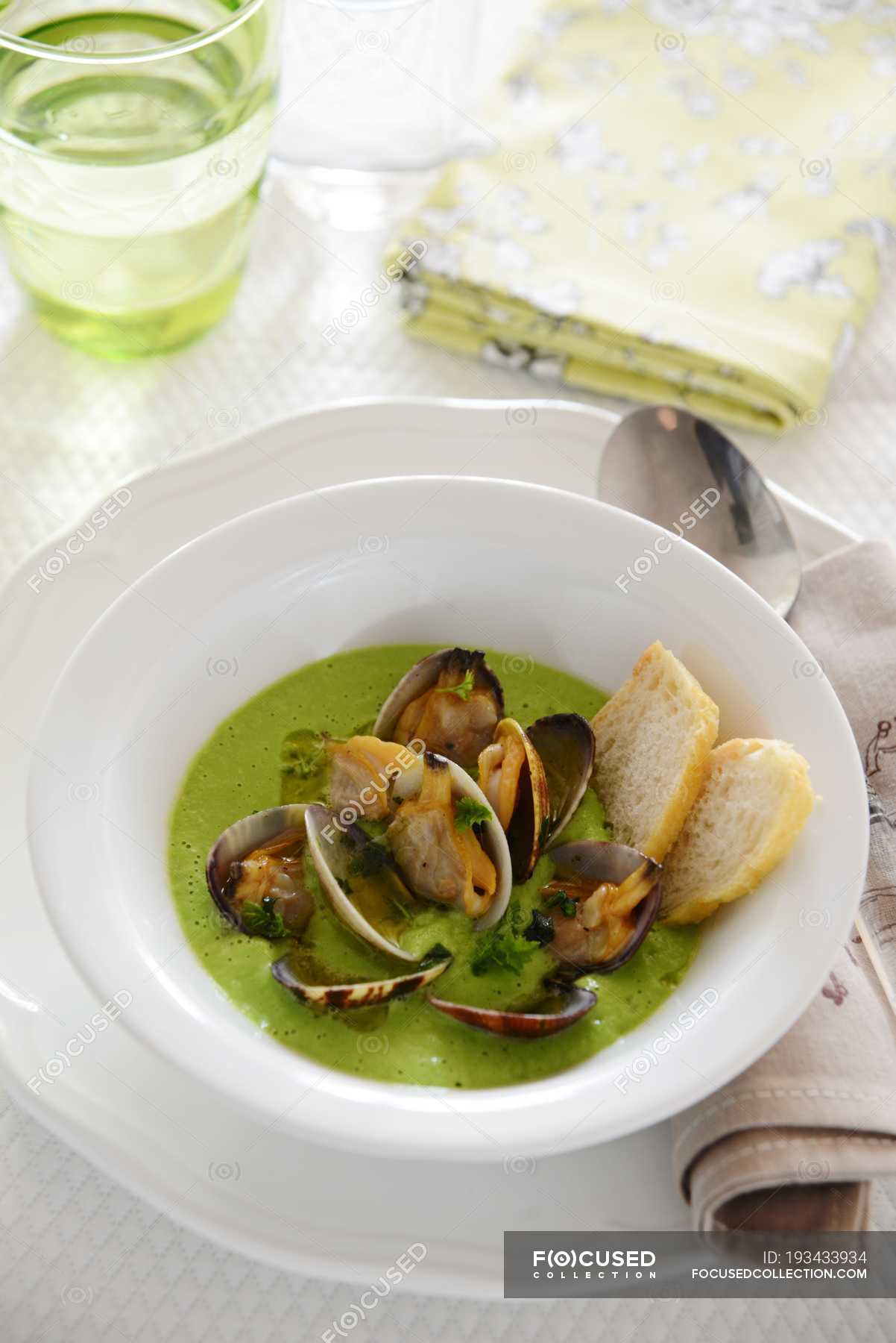 Tasty green pea soup with clams in bowl — appetizing, edible Stock