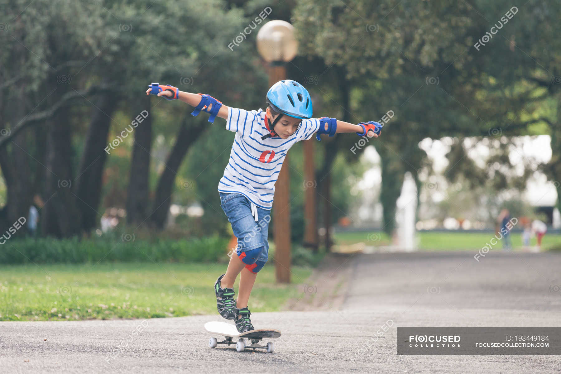 Boy wearing helmet skateboarding in park — motion, playing Stock