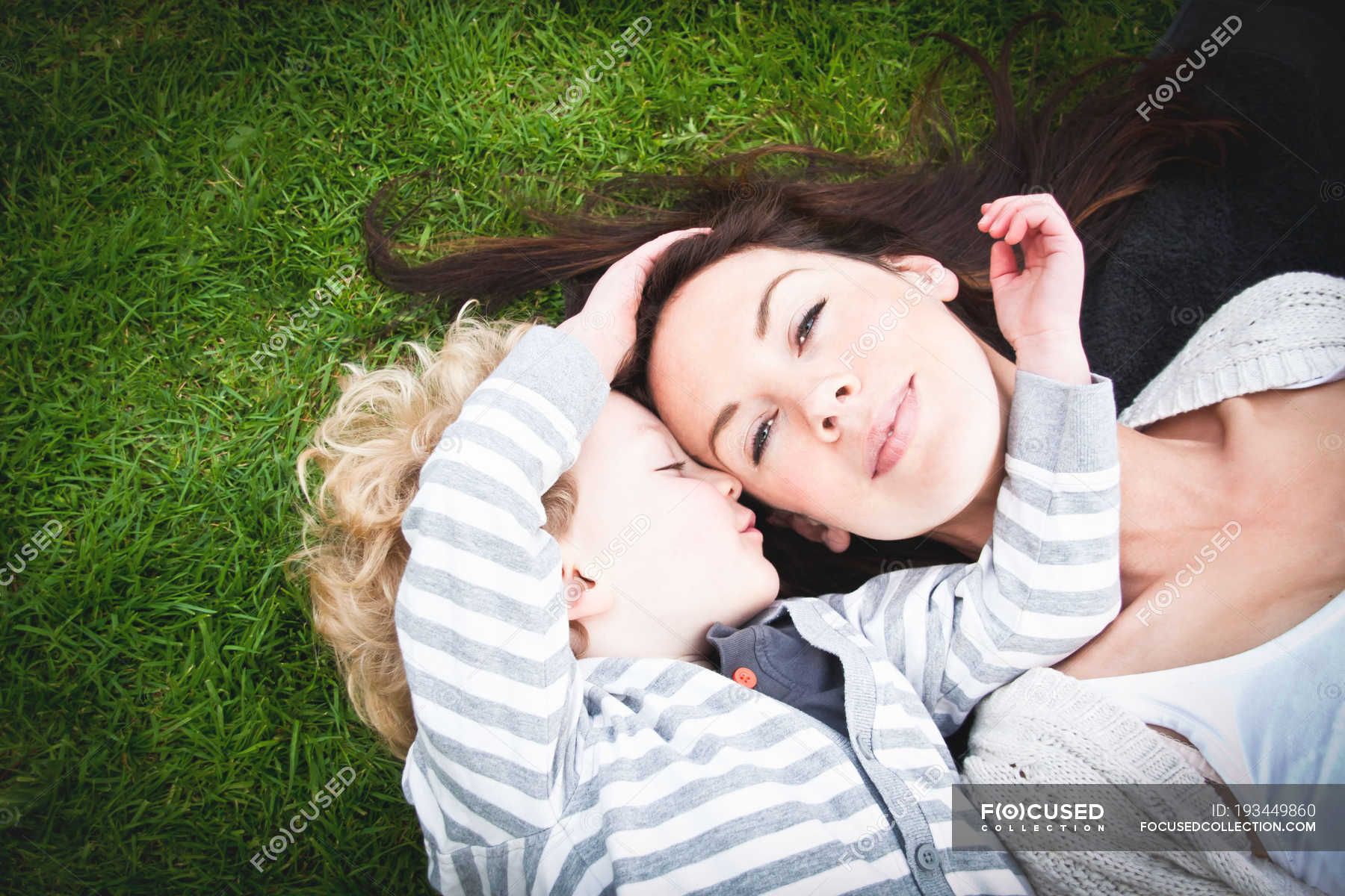 Fils couché avec les bras autour du visage de la mère — préscolaire, gamin Stock Photo