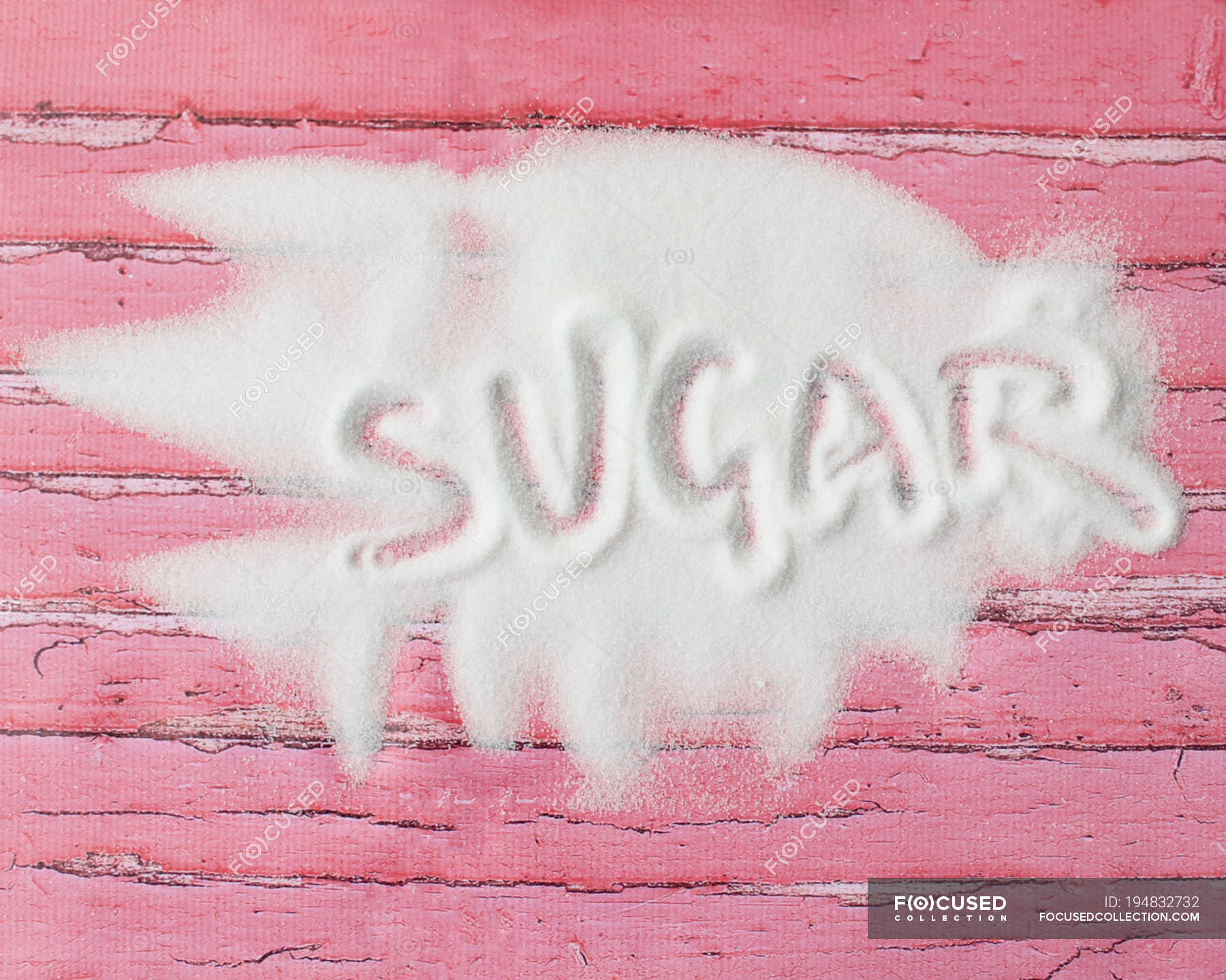 Word sugar written in sugar on pink wooden table — minimal, message